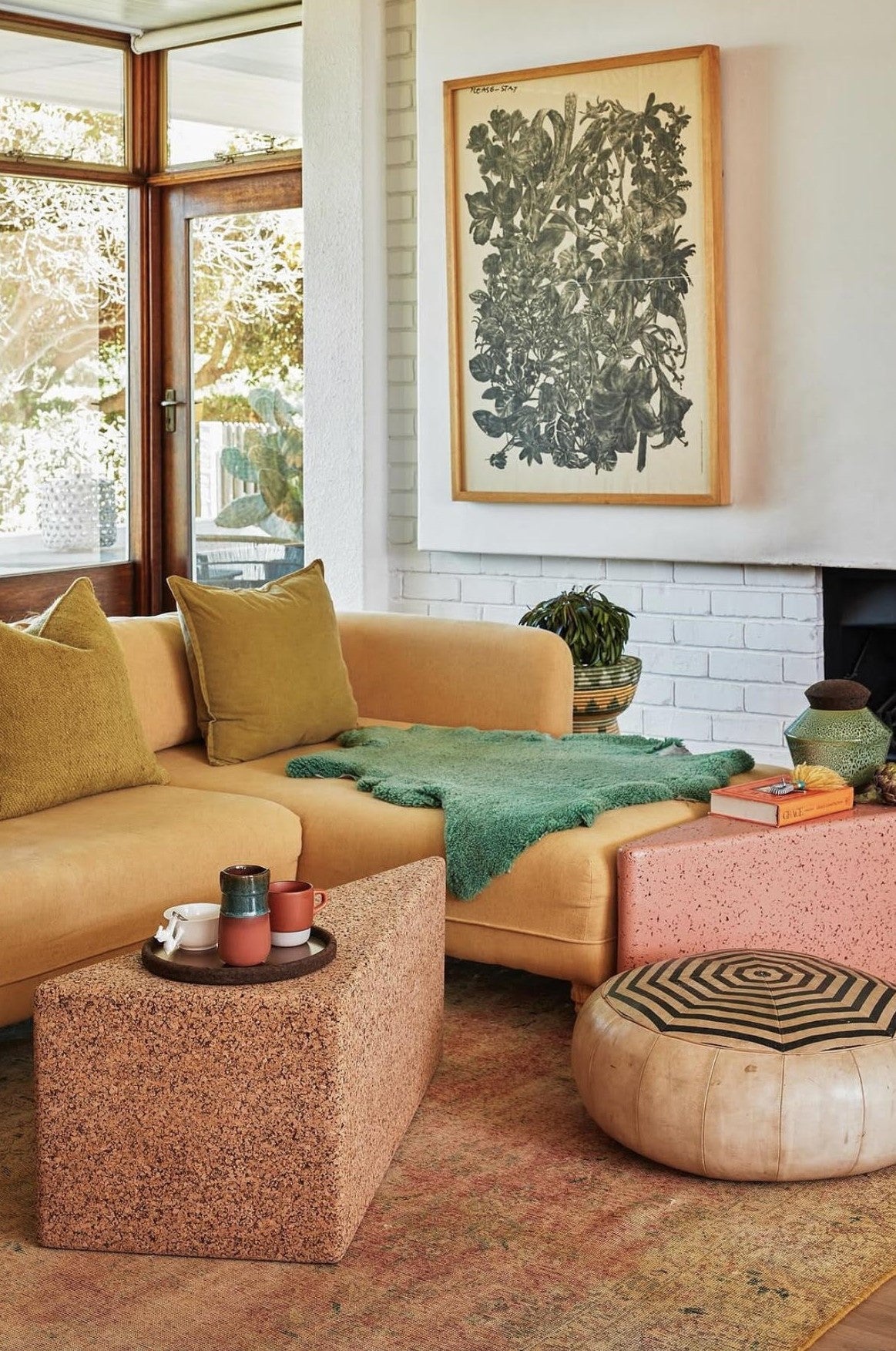 Showcasing the Wiid designs in living room, triangle coffee table, end table, side table. This innovative design by Wiid integrates the earthy texture of dark cork with the solid stability of a concrete and terrazzo base, creating a visually striking and sustainable seating option for contemporary bars and kitchens.