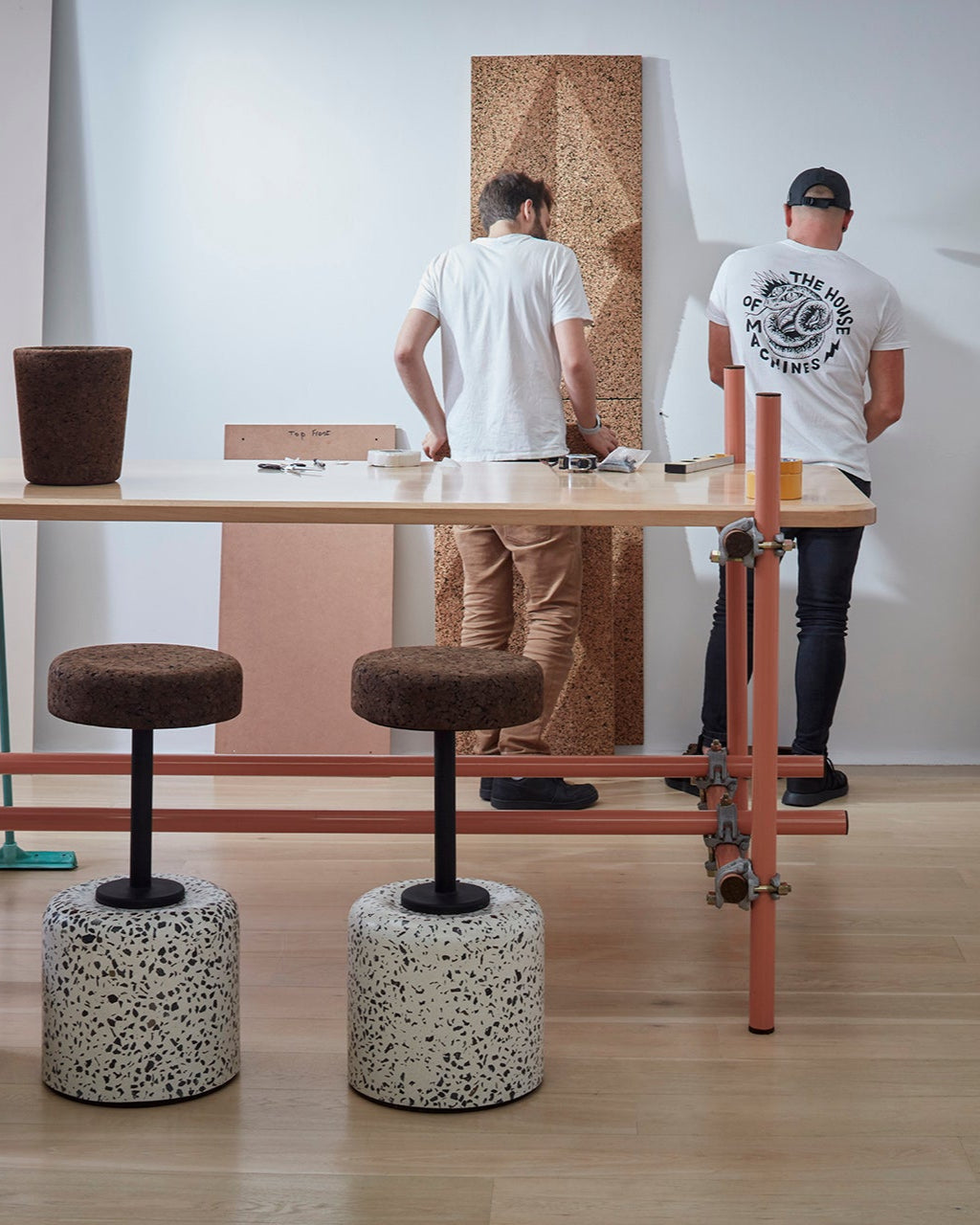 Inside the Wiid studio showroom, the Wiid Cork and Concrete Swivel Barstool in Terrazzo and Dark Cork is elegantly displayed against a backdrop of striking Wiid cork panels. This scene captures the essence of the brand's innovative design philosophy, featuring the barstool's sleek terrazzo base and comfortable dark cork seat amidst a creative installation. It exemplifies how functional art can transform any space, showcasing sustainable materials and contemporary aesthetics.