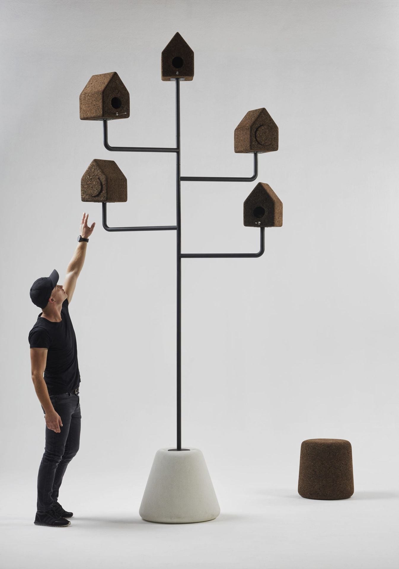 Designer Laurie Wiid van Heerden stands beside the Luxury Wiid Design Bird House, providing scale to the eco-friendly dark cork structure with its durable concrete base. This image highlights the impressive size and elegant design of the birdhouse, showcasing Laurie’s commitment to creating sustainable, functional art for outdoor spaces.