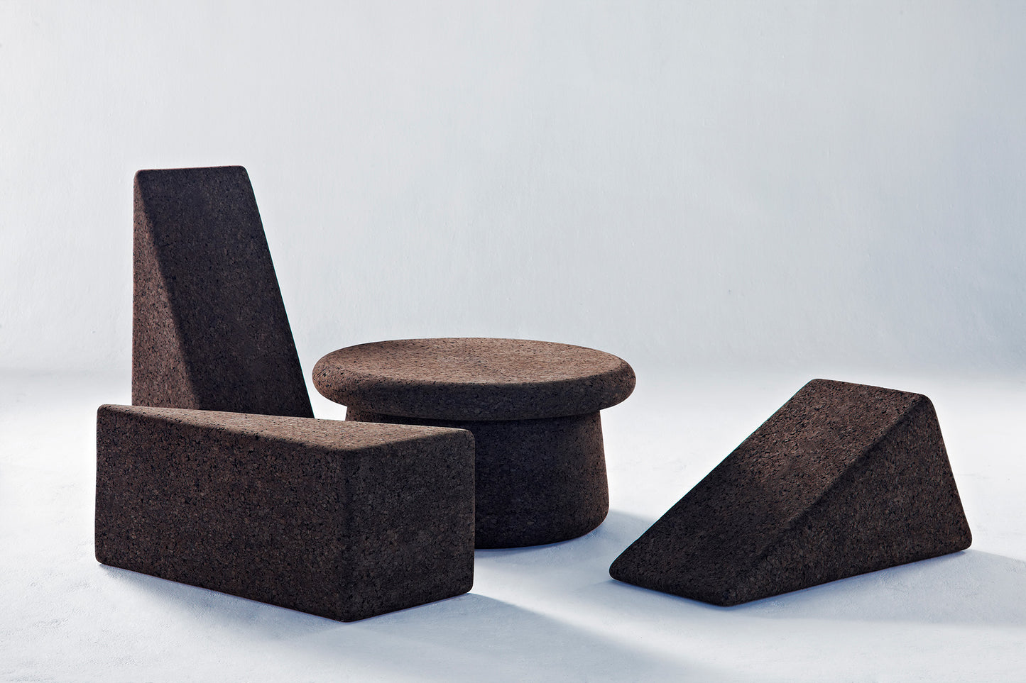 Kanju presents a stylish duo: the Wiid Cork Low Table and Wiid Triangle Cork Table/Seat, both in elegant dark cork. This image captures their versatility and modern design, highlighting the sustainable dark cork's rich texture. Perfect for contemporary spaces, these pieces offer eco-friendly sophistication and multi-functional appeal, blending seamlessly with any decor.