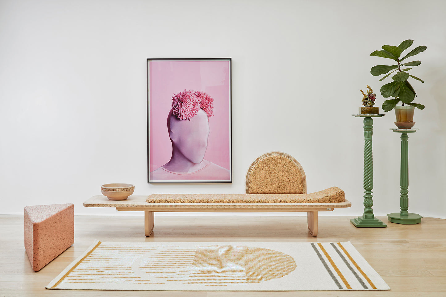 "Curated Kanju interior featuring the Wiid Triangle Cork Seat/Side Table in a soft pink hue alongside detailed craftsmanship of the Wiid Cork & Soft Maple Wood Meraki Daybed. This pairing highlights sustainable luxury with a focus on innovative design, showcasing the seamless blend of functionality, comfort, and style in modern home decor.