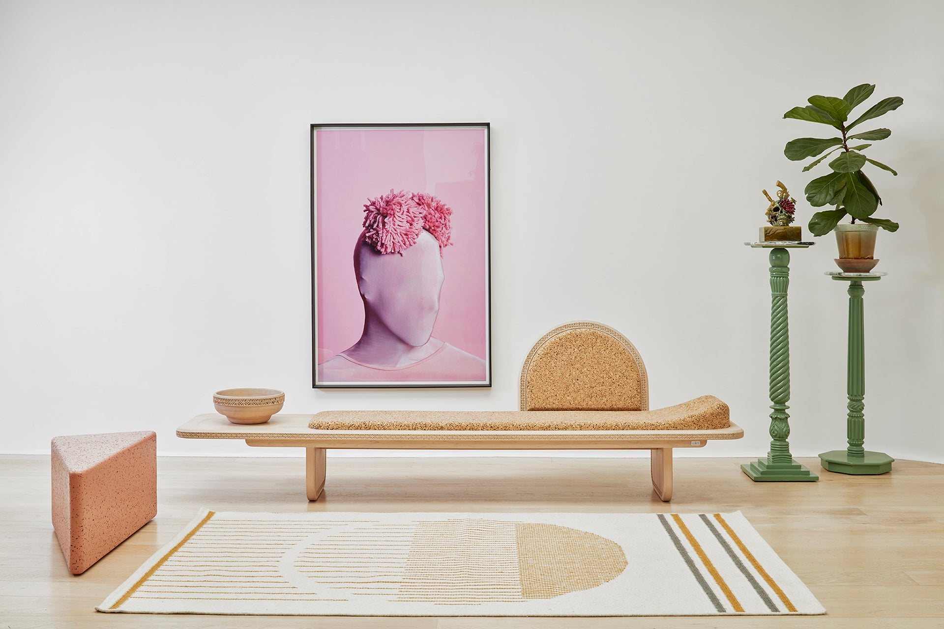 "Curated Kanju interior featuring the Wiid Triangle Cork Seat/Side Table in a soft pink hue alongside detailed craftsmanship of the Wiid Cork & Soft Maple Wood Meraki Daybed. This pairing highlights sustainable luxury with a focus on innovative design, showcasing the seamless blend of functionality, comfort, and style in modern home decor.