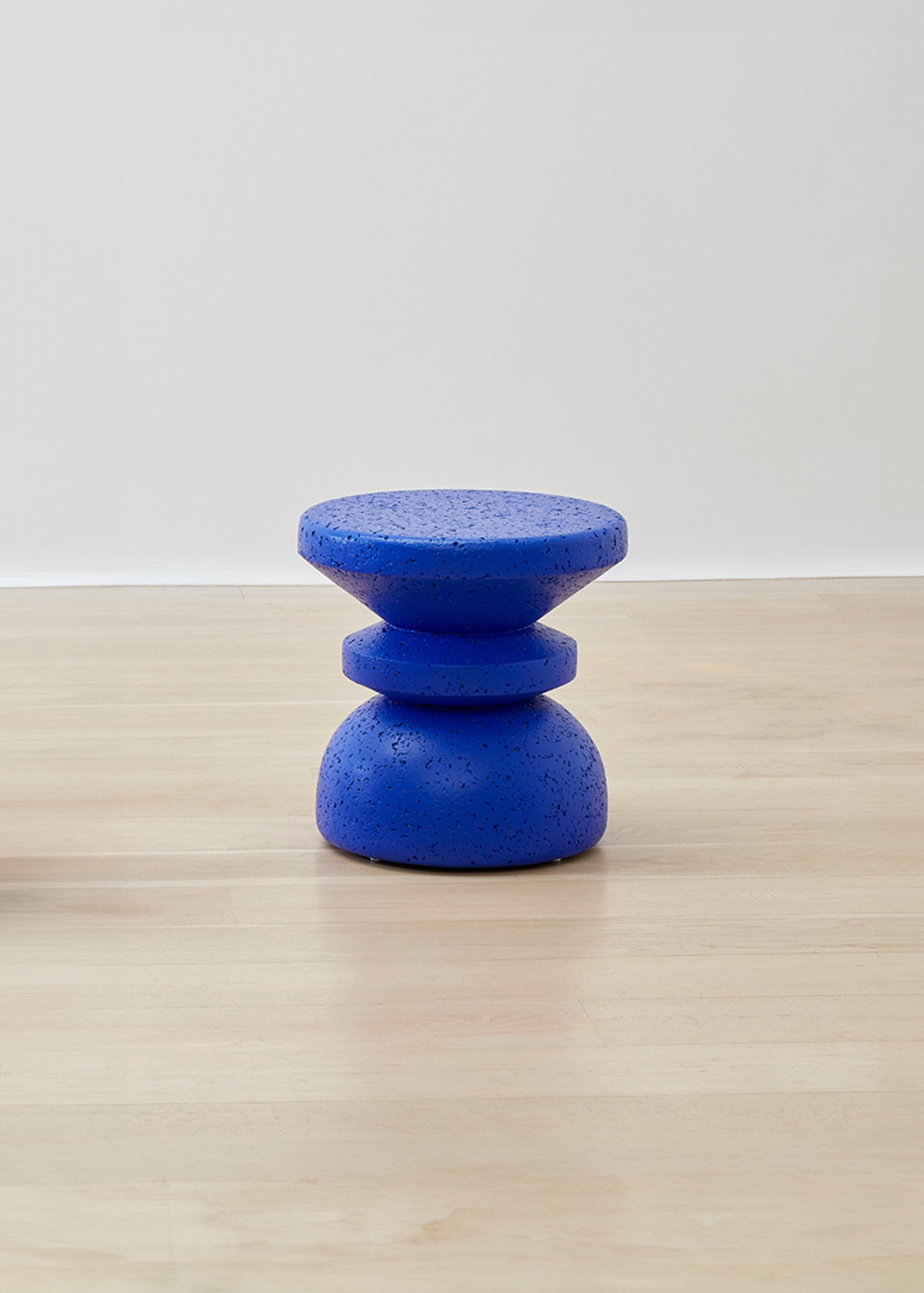 Kanju's Wiid Painted African Stacked Cork Stool in a deep blue, exemplifying a blend of modern design and sustainability. The layered cork construction is highlighted by the rich blue finish, offering a unique, eco-friendly seating solution that adds a touch of sophistication and bold color to any space.