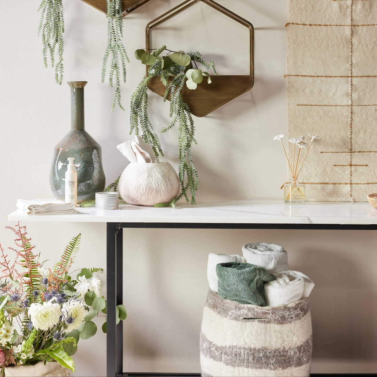 Decorative setup with hexagonal wall planters, a pumpkin, and a vase on a shelf.