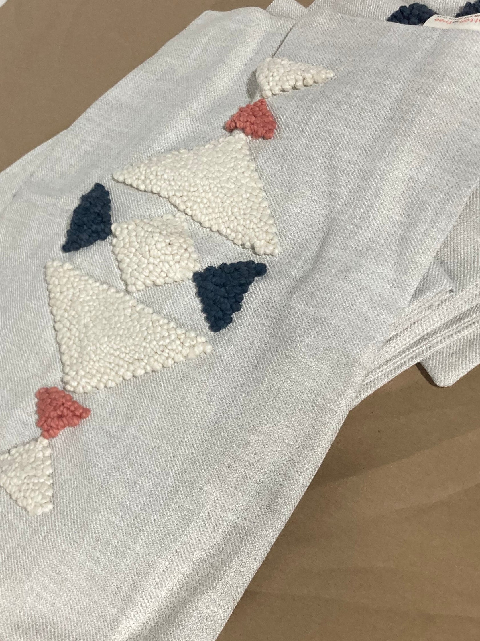 Stack of embroidered fabric napkins on a wooden surface