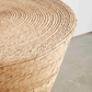 Close-up of a woven wicker stool with a neutral background