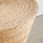 Close-up of a woven wicker stool with a neutral background
