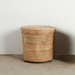 Woven basket on a concrete floor with a white wall background