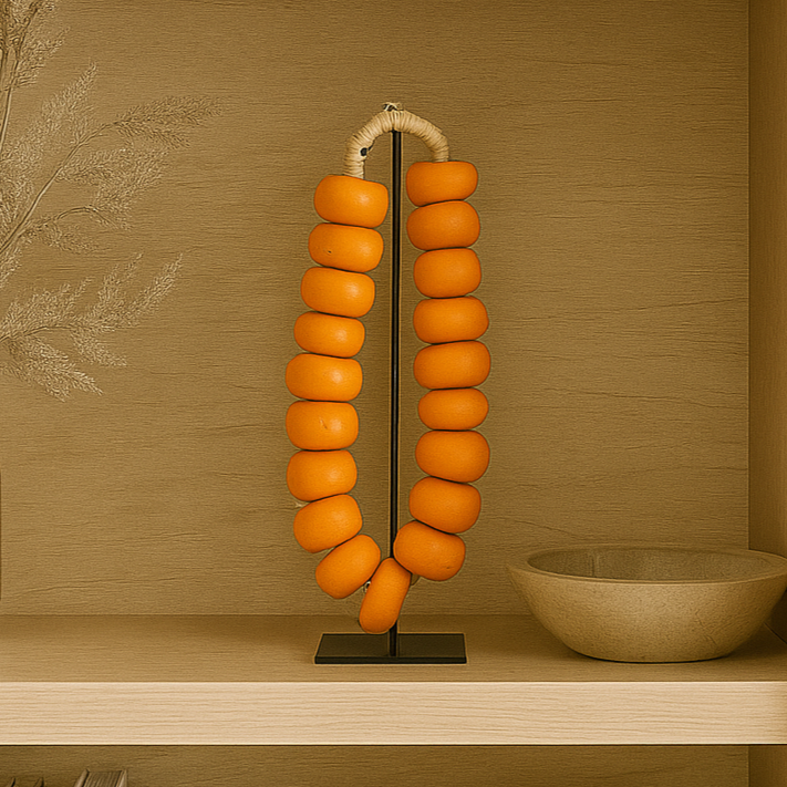 Decorative orange lamp on a shelf with books and a bowl