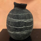 Textured black and gray spherical object on a brown surface