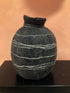 Textured black and gray spherical object on a brown surface