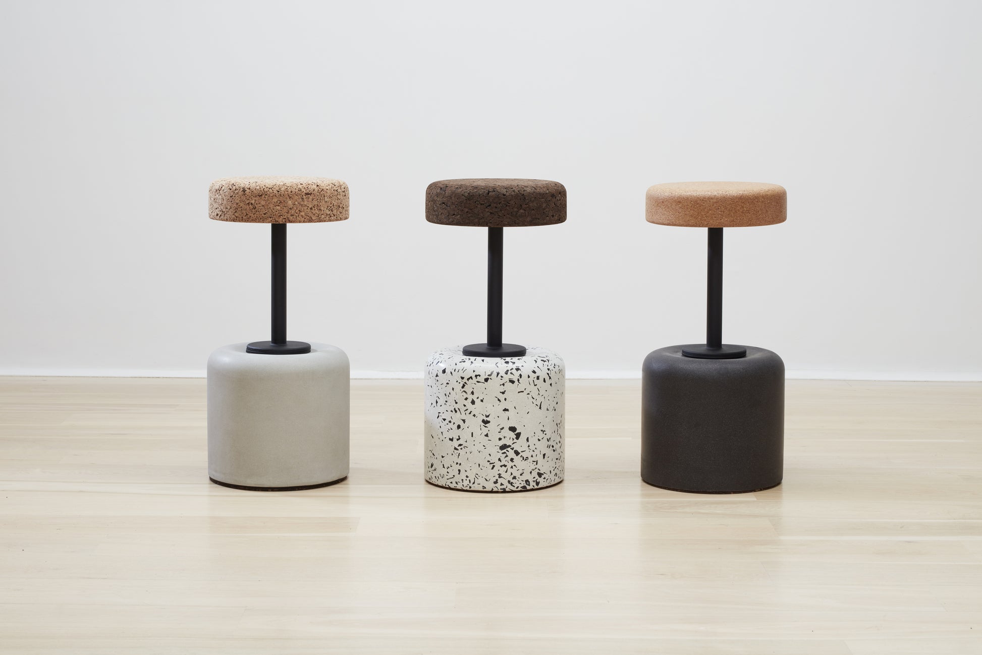 Collection of Kanju's Wiid Swivel Cork and Concrete Barstools showcasing a variety of finishes: Terrazzo, Natural Grey, and Charcoal Base. This image highlights the diversity and sophistication of the designs, featuring the unique texture of cork combined with durable concrete bases in different hues. Each barstool offers a blend of sustainable materials, swivel functionality, and contemporary style, suitable for modern bars and kitchens.