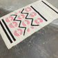 Decorative mat with pink leopard print and black zigzag pattern on a metallic surface