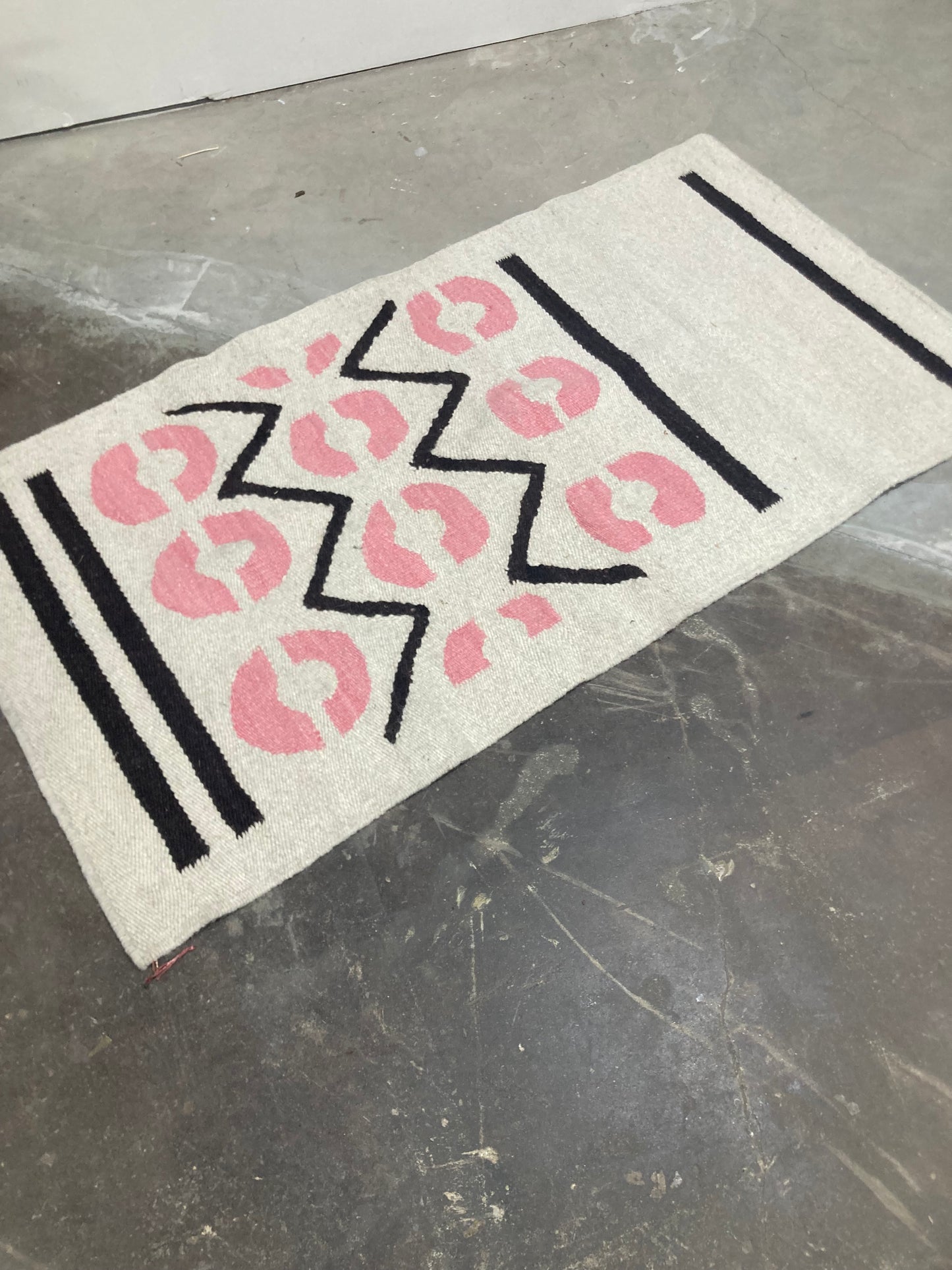 Decorative mat with pink leopard print and black zigzag pattern on a metallic surface