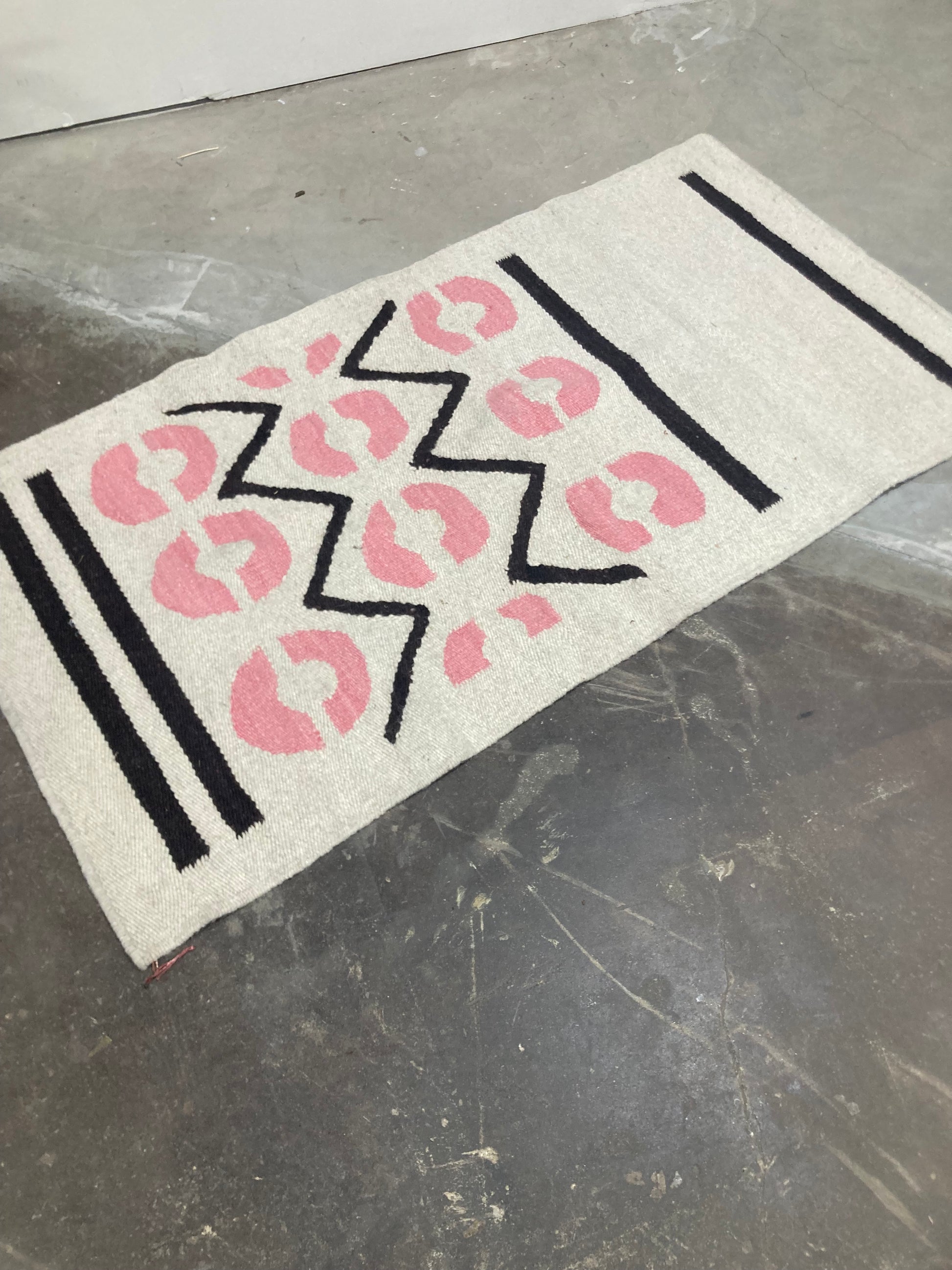 Decorative mat with pink leopard print and black zigzag pattern on a metallic surface