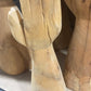 Wooden mannequin hands and arms stacked together on a surface.