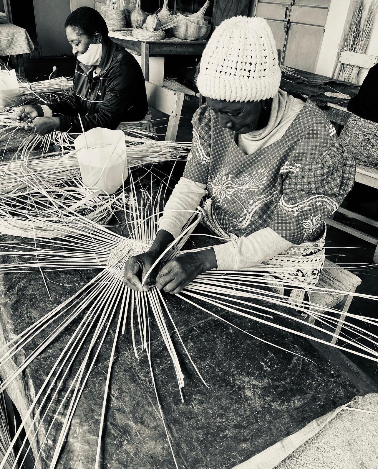 Artisans at work crafting Kanju Garlic Gourd Baskets, capturing the essence of African luxury craftsmanship. This image shows the skilled process of weaving, highlighting the traditional techniques used to create these unique, high-end home decor items.