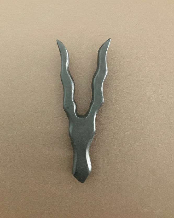 Metallic tool with a unique design on a beige background
