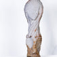Decorative stone sculpture of a draped figure on a white background