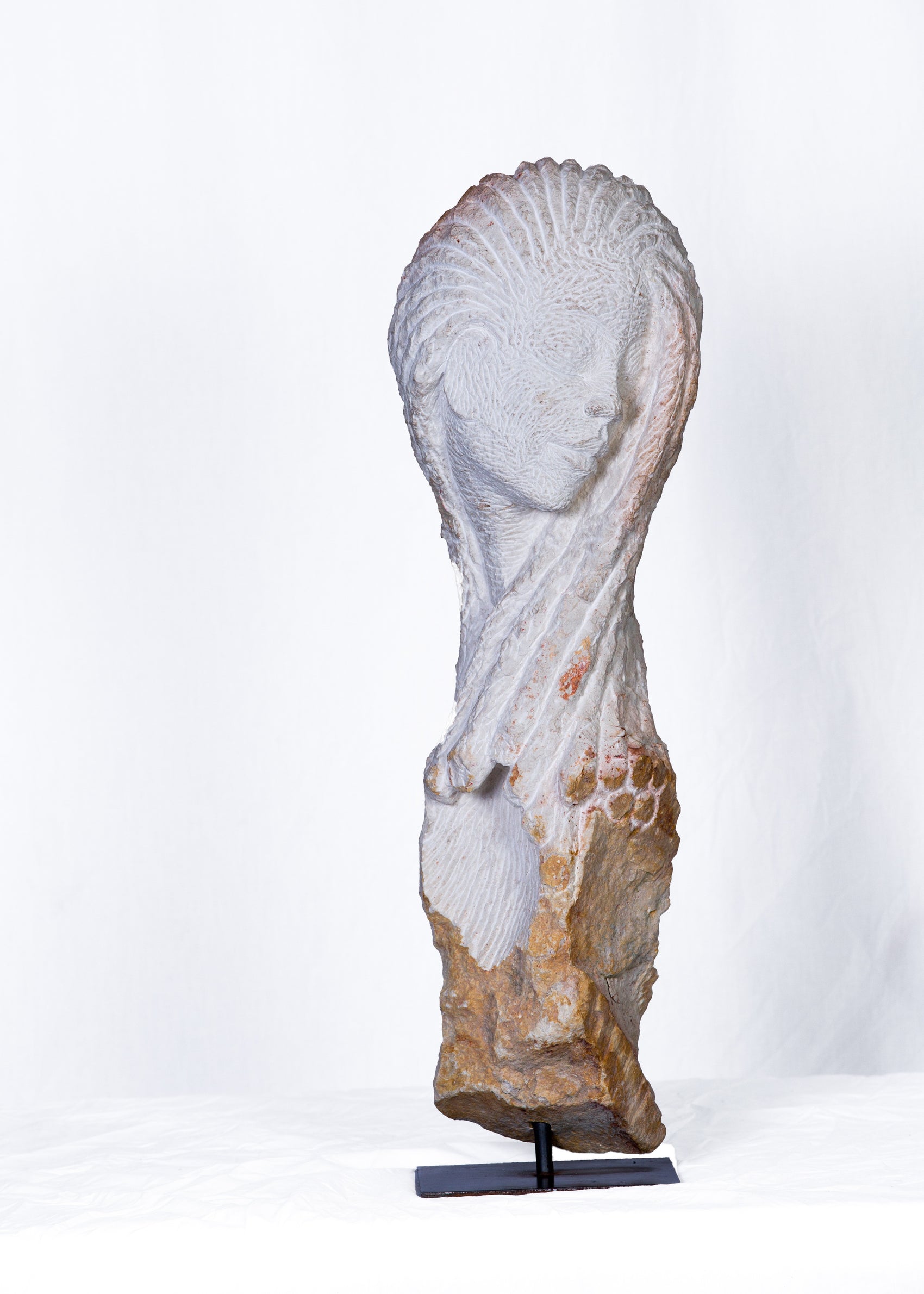 Decorative stone sculpture of a draped figure on a white background
