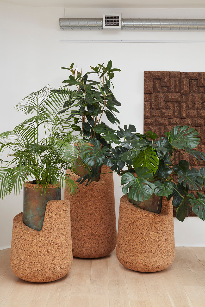 Set of three Kanju Wiid Angled Cork Planters, each featuring a distinctive asymmetrical design with a rustic natural cork exterior and an aged copper-green patina interior, exuding an earthy yet refined aesthetic for luxury home decor.