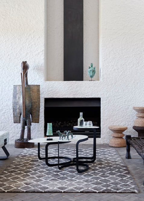 A gray wool Berber rug with a geometric diamond pattern, displayed in a room with modern furniture.