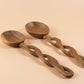 Two wooden ladles with braided handles on a white background
