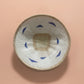 Woven basket with blue patterns on a pink background