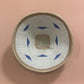 Woven basket with blue patterns on a pink background