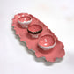 Pink ceramic tray with three bowls on a white background