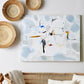 Living room with wicker furniture, decorative plates, and abstract art on a white wall.