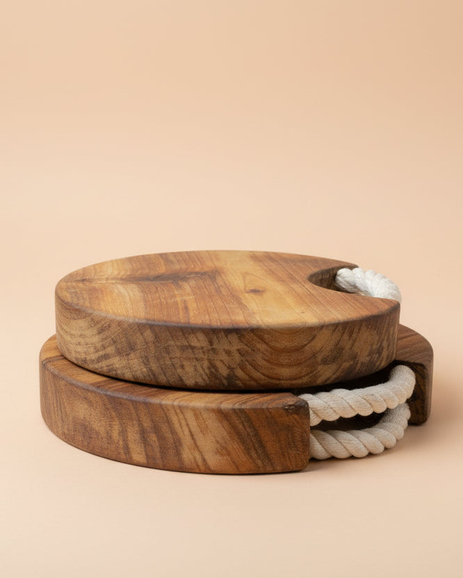 Wooden cutting board with a rope handle on a beige background