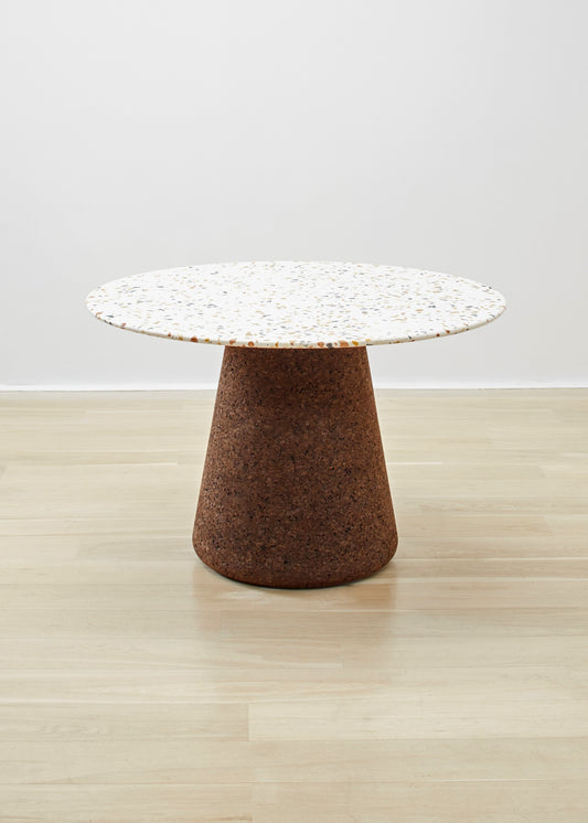 Elegant Kanju's Wiid Terrazzo and Cork Dining Table in Dark Cork, a masterpiece by Wiid Design, combines the raw beauty of terrazzo with the warmth of dark cork. This luxurious dining table not only stands as a testament to sustainable design but also to modern craftsmanship, making it a focal point in any sophisticated dining space.