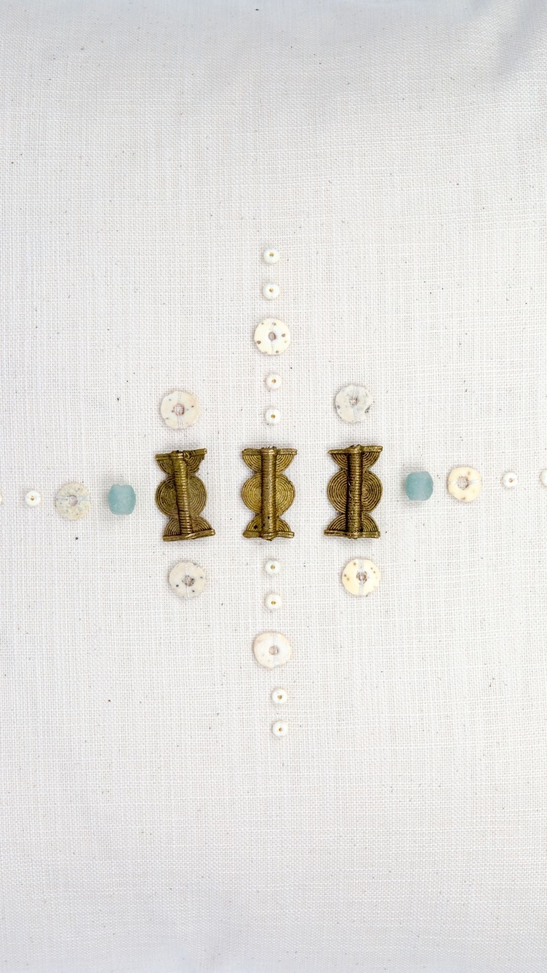 Pair of earrings with gold and bronze designs on a white background