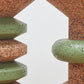 Detail close-up of Kanju's Wiid Green Banded Tall African Cork Side Tables, highlighting both the Stacked and Ringed designs. This image captures the intricate craftsmanship and vibrant green accents against the natural cork, showcasing the tables' unique textures and sustainable elegance. Ideal for adding a touch of artistry and eco-conscious design to any interior space.