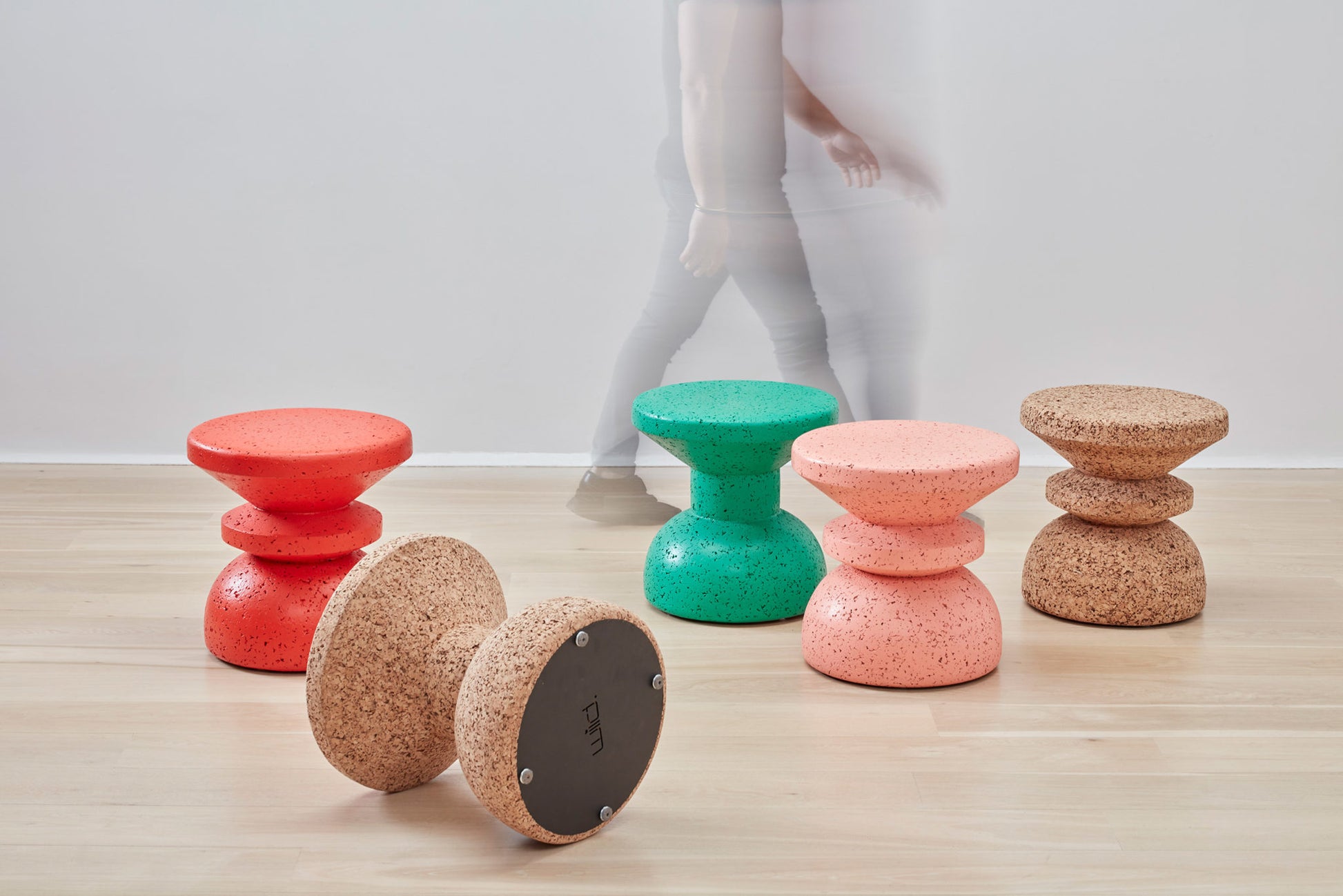 Vibrant collection of Kanju Wiid Design African Cork Stools in an array of colors: bold red, soft pink, serene teal, and natural cork. Each stool showcases the exquisite craftsmanship and sustainable design, adding a pop of color and eco-friendly elegance to any space