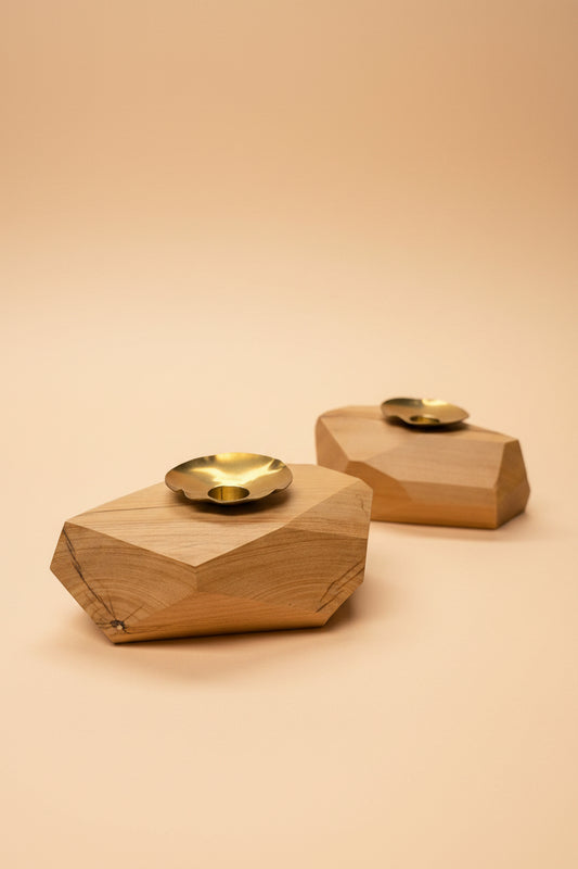 Wooden wall sconces with gold finishes on a peach  background