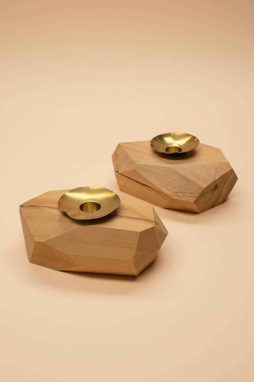 Two geometric wooden wall lights with gold circular elements on a peach background