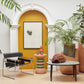 Kanju Interiors' sophisticated vignette featuring a Wiid Ceramic Oval Table, Green Banded Tall African Cork Side Table, and Angled Cork Planters, elegantly framed by an archway with mustard yellow accents and lush indoor plants, creating an ambiance of refined African luxury.
