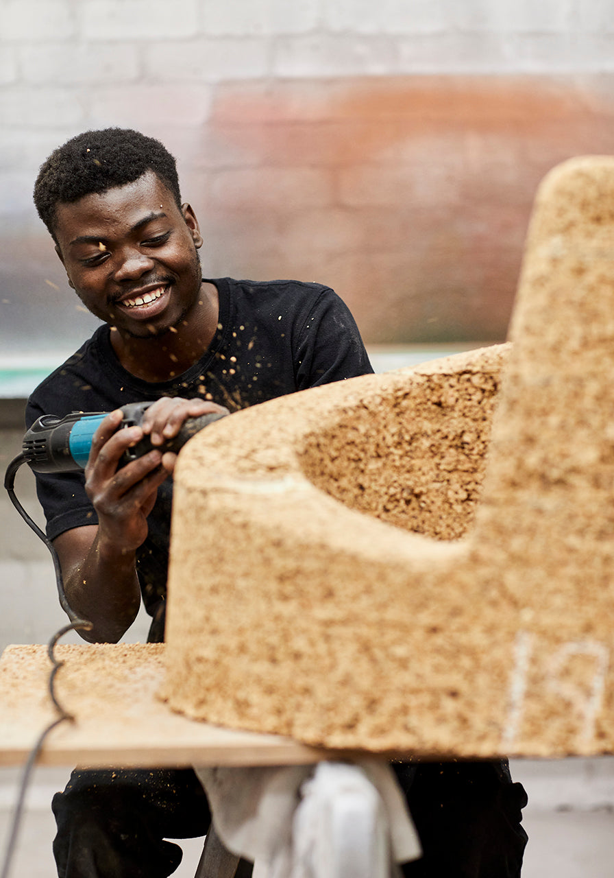 Behind-the-scenes look at the creation of Kanju's Wiid Angled Cork Planter, capturing the meticulous craftsmanship of skilled artisans. This image reveals the sustainable cork being shaped into the planter's distinctive angled design, highlighting the blend of traditional techniques and modern innovation unique to African luxury home decor.