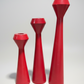 Set of three red candle holders on a white background