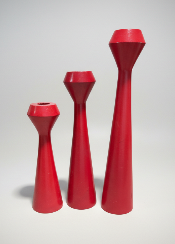Set of three red candle holders on a white background