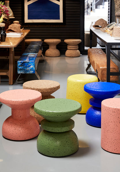 Kanju's collection of Wiid Painted African Cork Stools, featuring an array of styles including Stacked, Slim, and Round, each available in captivating shades of Coral, Cobalt, and Sage. This diverse range melds artisanal craftsmanship with eco-friendly innovation, offering versatile, stylish seating solutions that bring a burst of color and contemporary African design to any space