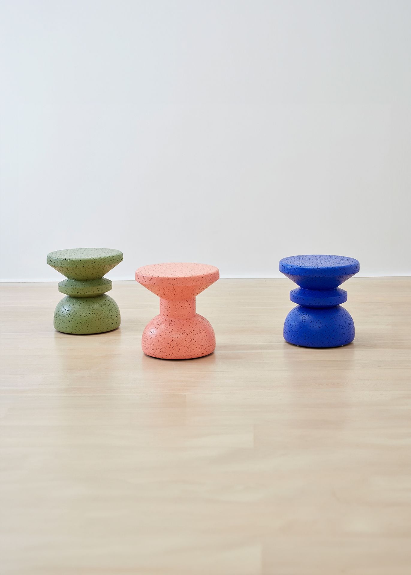Exquisite Kanju Wiid African Painted Cork Stool collection, showcasing Slim and Stacked designs in a palette of green, blue, and pink. Each stool blends vibrant color with sustainable cork craftsmanship, embodying a fusion of eco-friendly materials and bold, modern aesthetics. Ideal for interiors seeking a splash of color and unique, artisanal design.
