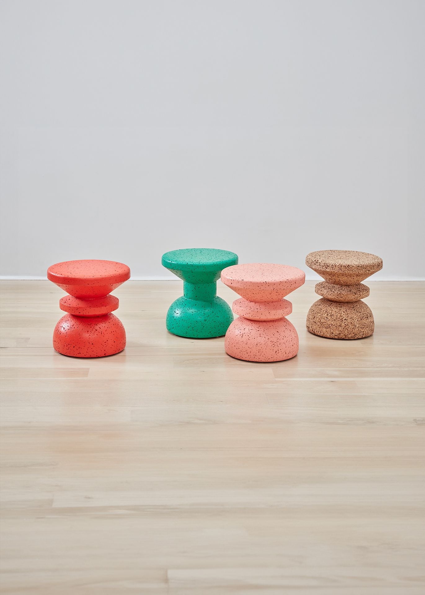 Vibrant collection of Kanju Wiid African Painted Cork Stools, featuring both Slim and Stacked designs in rich hues of red, teal, and pink. This assortment epitomizes sustainable luxury, with each stool's bold color and unique silhouette offering a distinct blend of modern design and traditional African craftsmanship, perfect for adding a pop of color and eco-friendly sophistication to any decor.