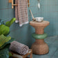 Chic bathroom setting featuring Kanju's Wiid Green Banded Tall African Cork Side Table with Ringed Design, perfectly complementing the space with its eco-friendly elegance. The image displays the table's unique ringed texture and vibrant green accent, adding a touch of sustainable luxury beside a freestanding bathtub, illustrating the versatility and modern aesthetic of cork in interior design