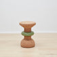 Showcase of Kanju's Wiid Green Banded Tall African Cork Side Table with a unique ringed design. This piece combines the natural texture of cork with a distinctive green band, creating a stylish and sustainable addition to any interior space. Perfect for those who appreciate eco-friendly luxury and innovative, artisan-crafted furniture.