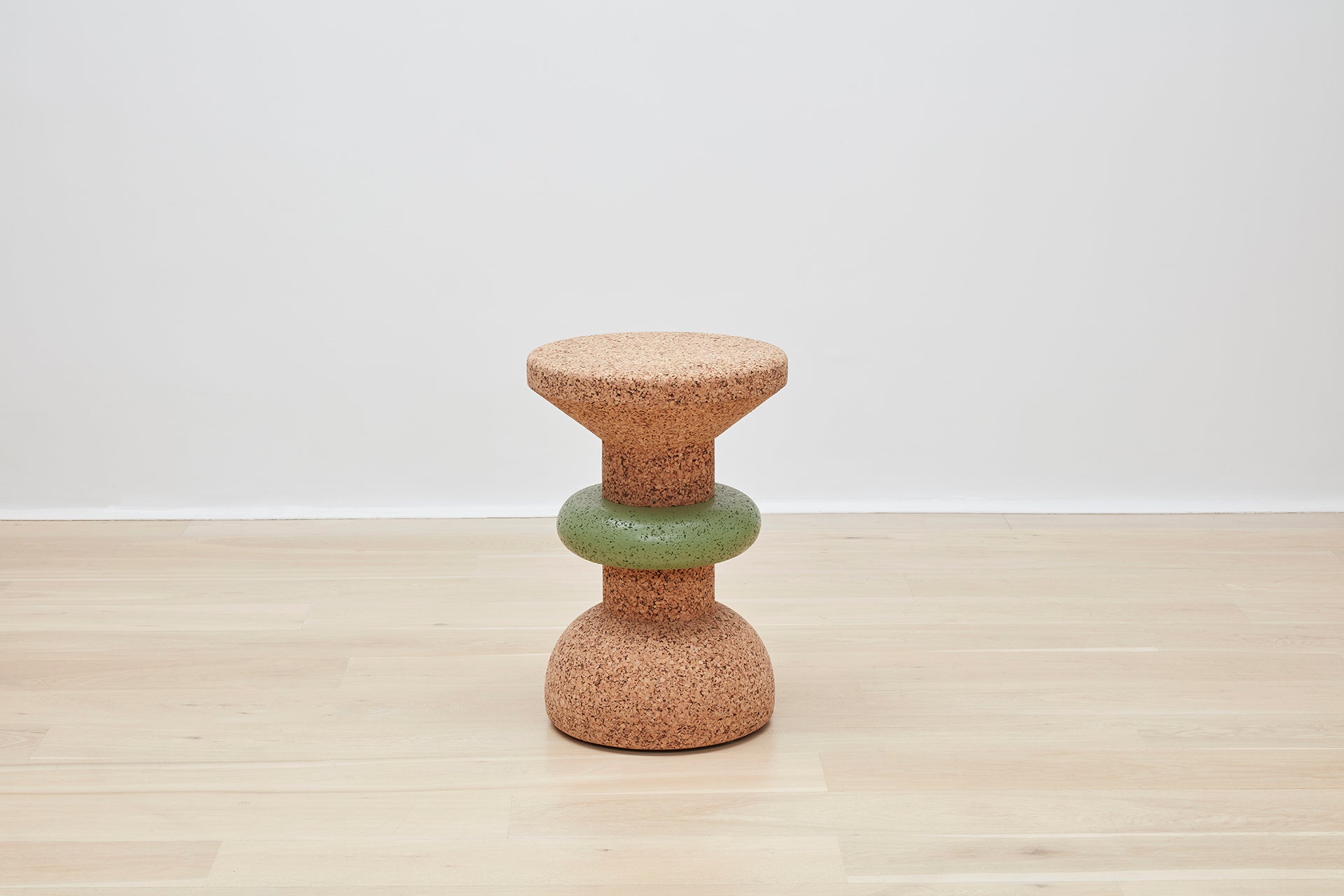 Showcase of Kanju's Wiid Green Banded Tall African Cork Side Table with a unique ringed design. This piece combines the natural texture of cork with a distinctive green band, creating a stylish and sustainable addition to any interior space. Perfect for those who appreciate eco-friendly luxury and innovative, artisan-crafted furniture.