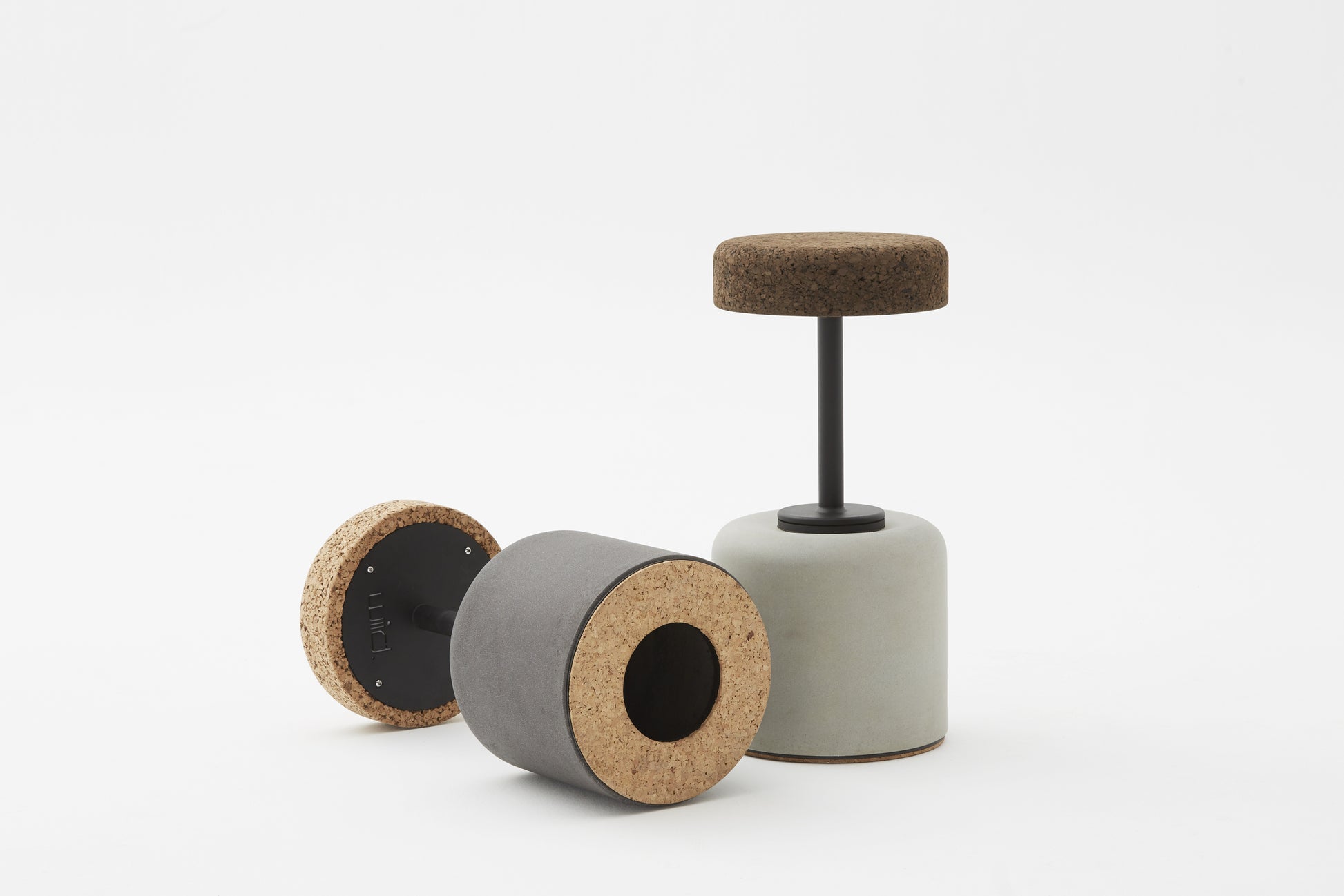 Close-up view of the bottom of Kanju's Wiid Swivel Cork and Concrete Barstool, highlighting the sturdy construction and innovative design. This image showcases the unique combination of natural cork and solid concrete, emphasizing the barstool's balance of eco-friendly materials with functional, contemporary style. The swivel mechanism is subtly integrated, offering both comfort and versatility in upscale bar settings.