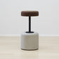 Elegant Wiid Cork and Concrete Bar Stools featuring a natural grey base paired with a dark cork seat, epitomizing modern sustainable design. This unique combination offers both aesthetic appeal and functional durability, making it a perfect addition to any contemporary kitchen or bar setting that values eco-friendly, high-quality furniture
